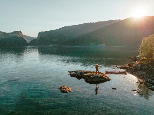 A nature view from Norway with mountains and water in the sun set.