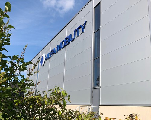 Our Alfa Mobility warehouse with blue Alfa logo at our Alfa office in Jönköping towards a blue sky. 