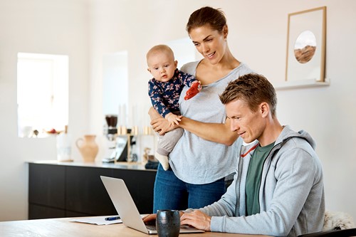 A family of three by the computer in their house planning for their international move of household goods with Alfa.