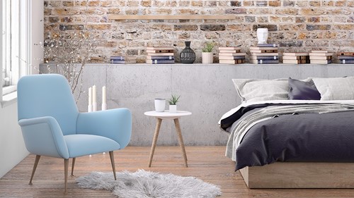 An interior of a furnished bedroom in an apartment showing a bed, armchair, pots with plants etc.