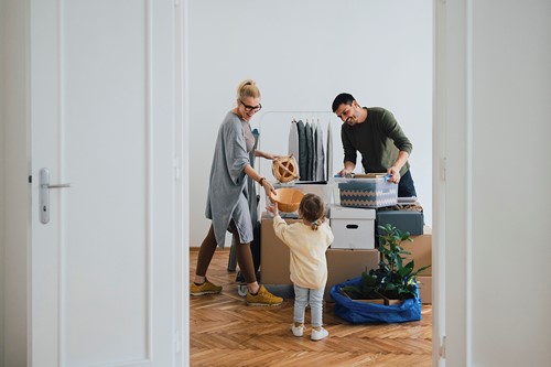 A family of three preparing for a pre-move survey preparing their household goods viewed from the doorway.