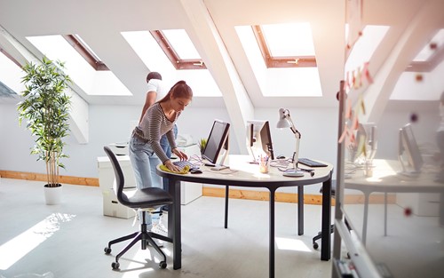 Professionelt rengøringspersonale som gør rent i en lys lejlighed på øverste sal med adskillige vinduer, for at sikre at lejligheden efterlades i perfekt rengjort stand.