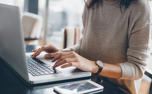 A girl typing at her computer in the office supporting customers.